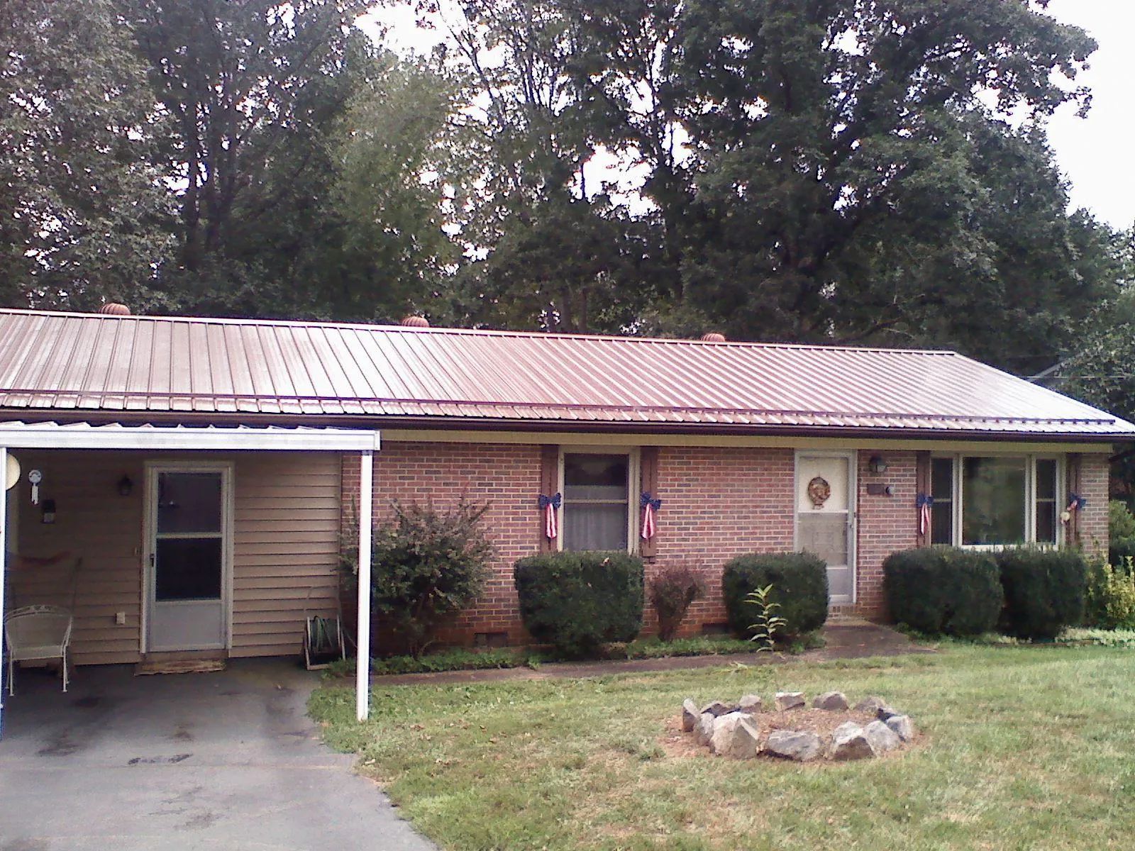 Bronze metal roof and carport on a brick ranch home — Roof Repair work by our crew in Pine City
